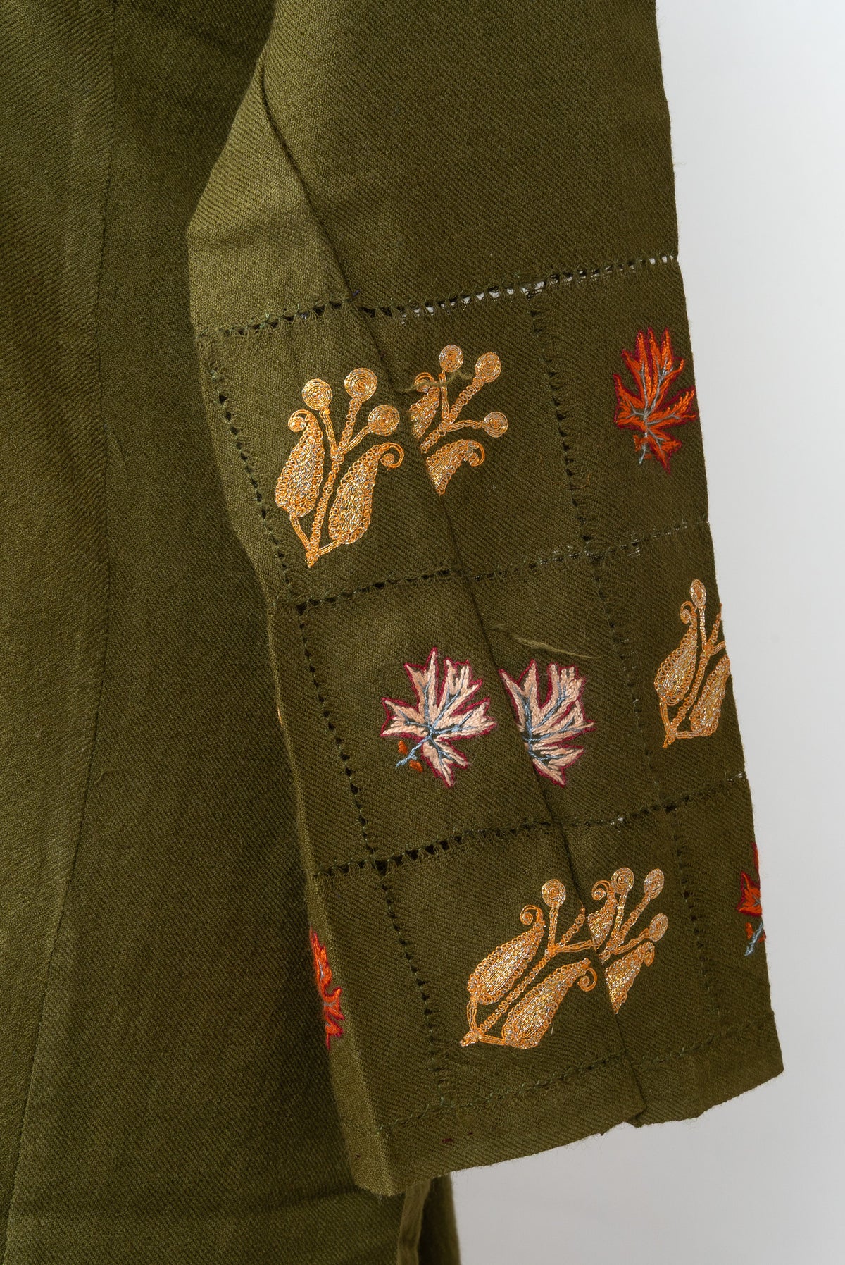 Hanging sleeve of an olive-green pheran with golden Sozni floral motifs and orange and pale pink leaves across the cuff
