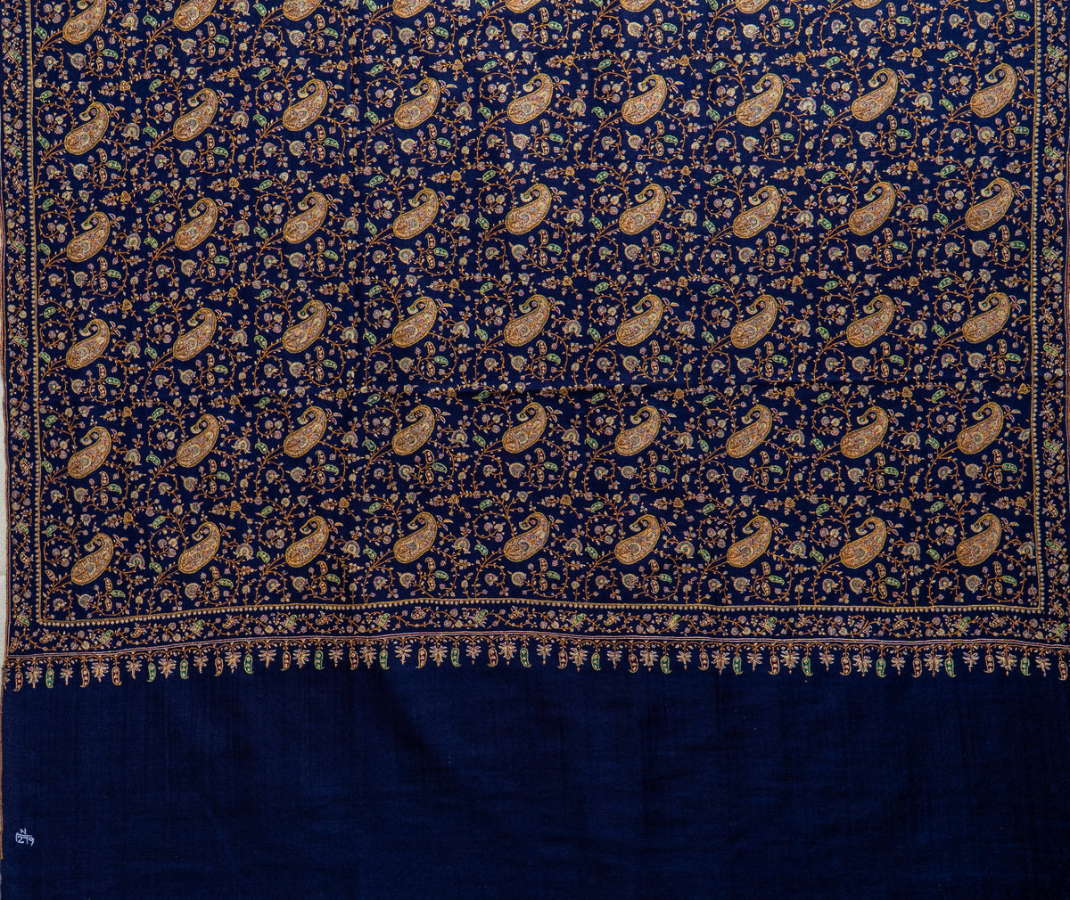 Midnight-blue Pashmina shawl laid flat, with dense Sozni paisleys and floral vines above a plain blue end