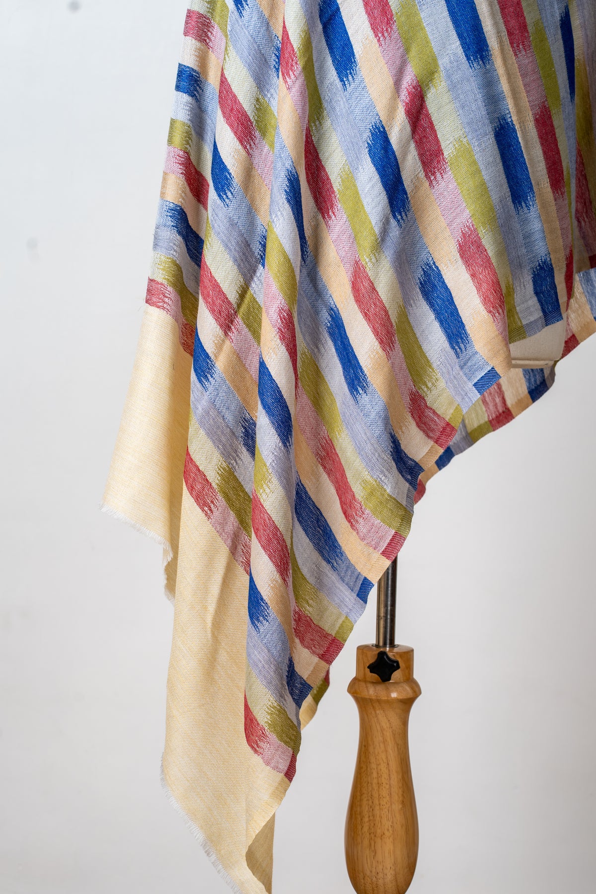 Detail of the printed stole’s hanging folds, colourful brushstroke stripes and plain cream end