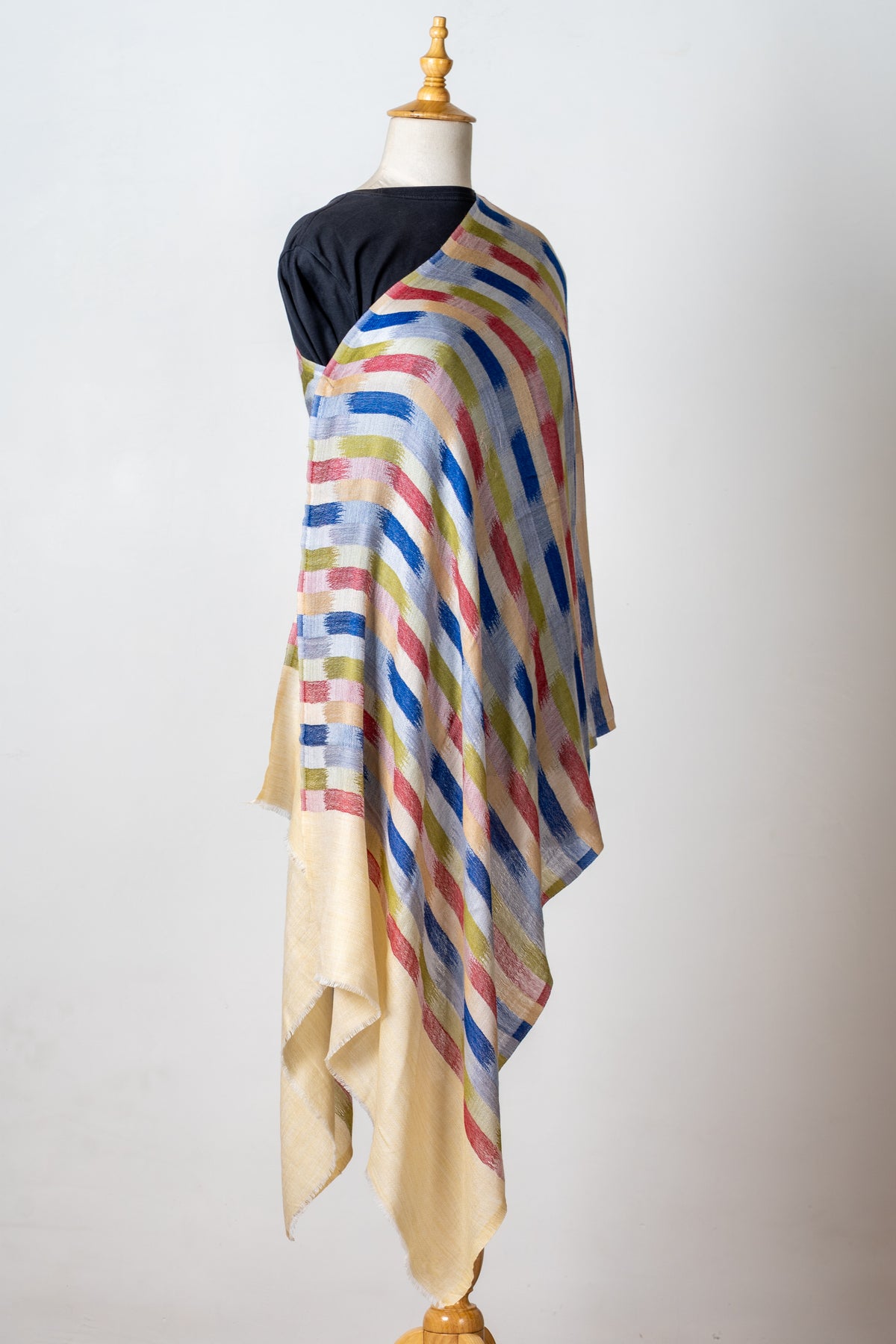 Side view of the printed Merino wool stole draped over a mannequin, showing colourful stripes and long plain cream ends