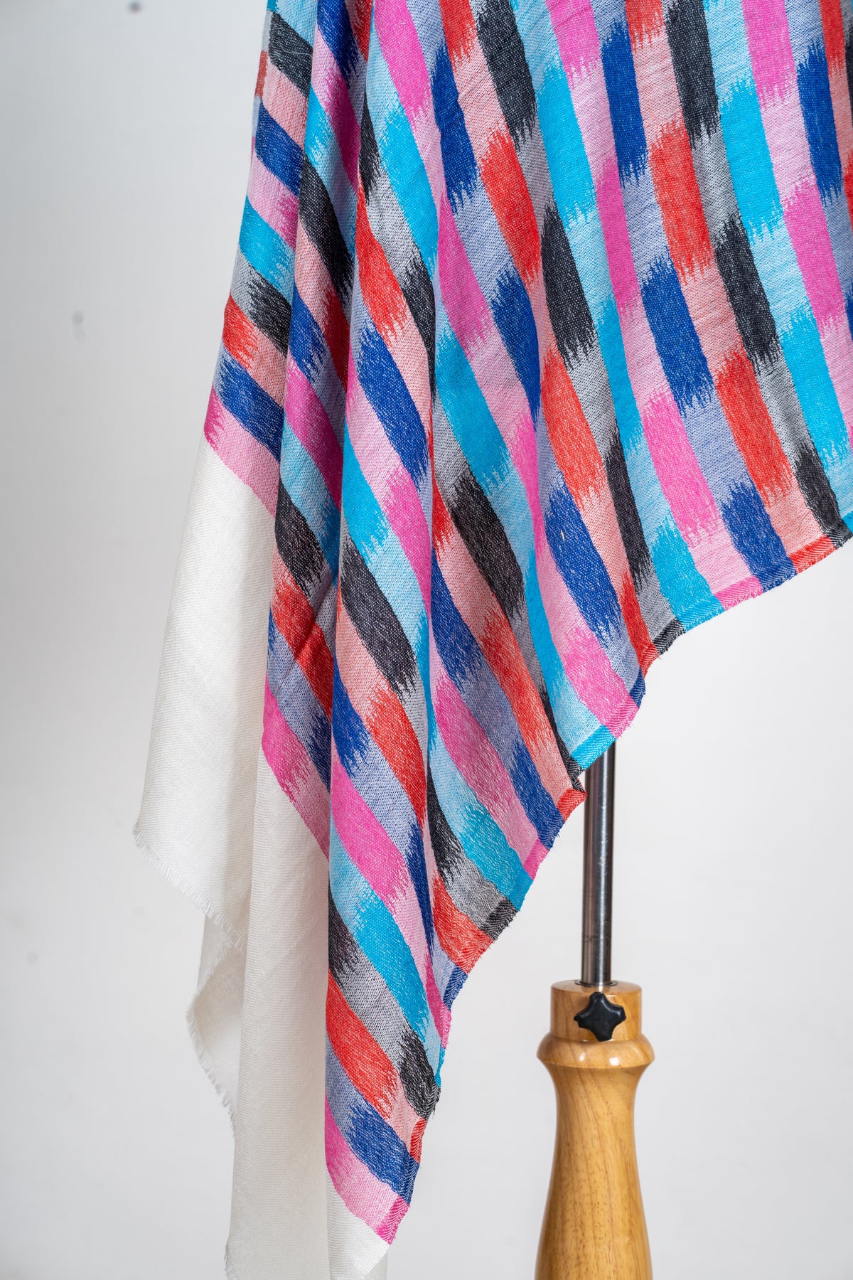 Detail of the printed stole’s hanging folds and colourful brushstroke checks above a plain ivory end