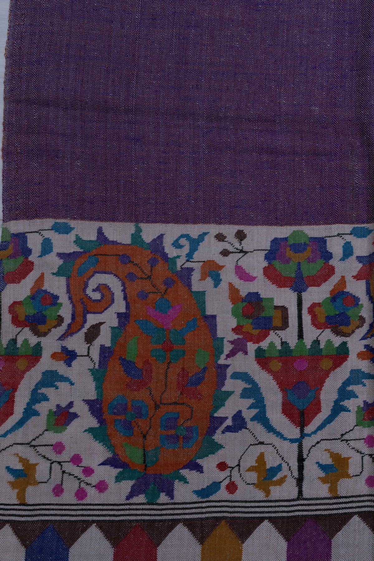 Close-up of the purple Pashmina shawl's ivory end panel, with a large orange paisley and colourful floral motifs.