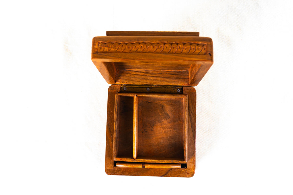 Overhead view of the open walnut wood box with a narrow compartment beside a larger rectangular tray section.