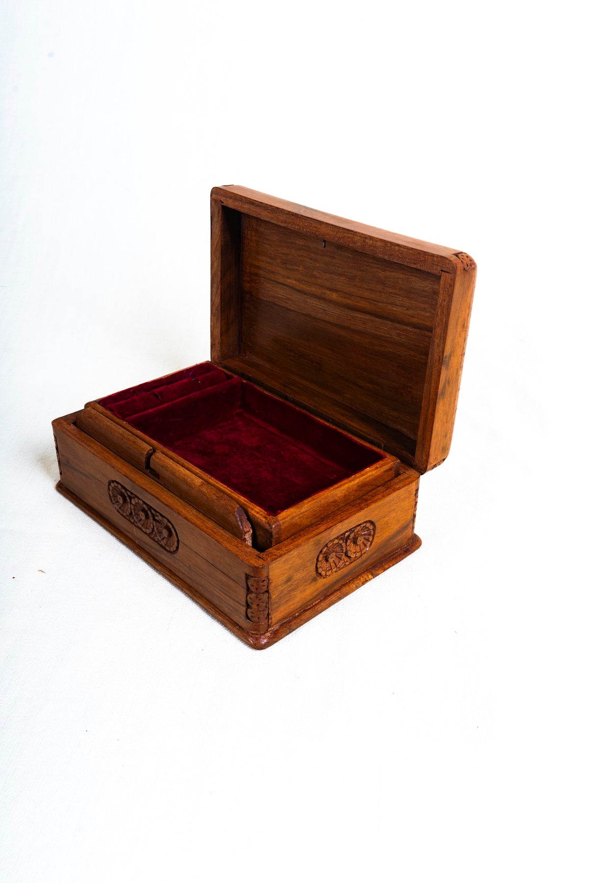 Open walnut box from the opposite corner, showing its red-lined interior and carved floral side medallions.