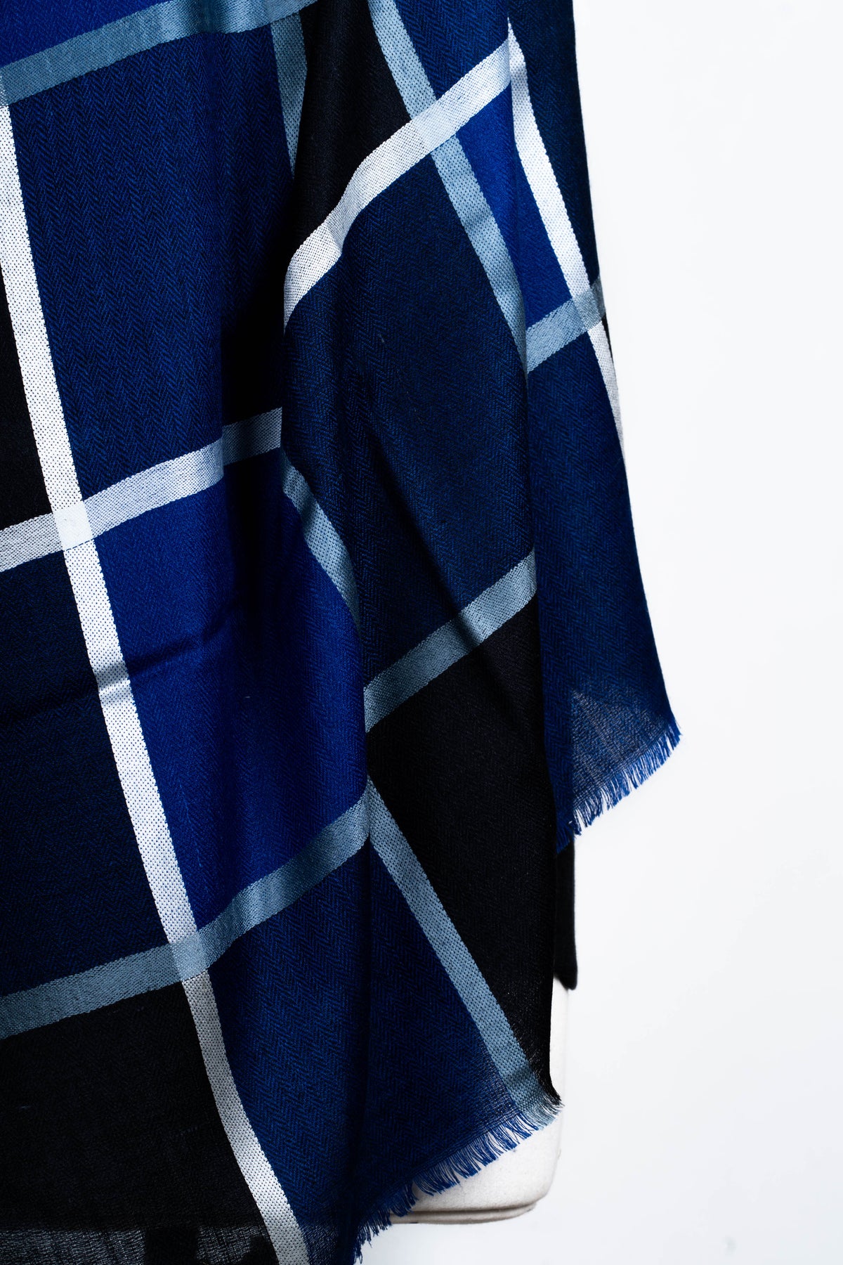 Detail of the navy checked stole’s hanging ends, with white lines, black panels and short fringe