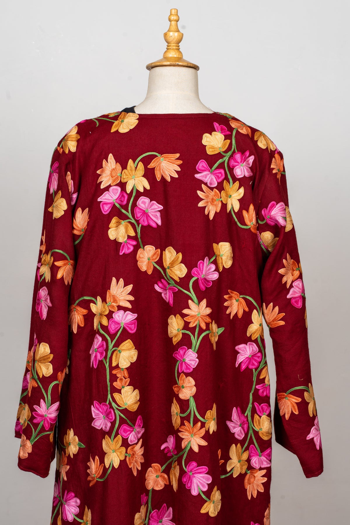 Back view of the crimson abaya covered in pink, orange and yellow flowers on curling green stems