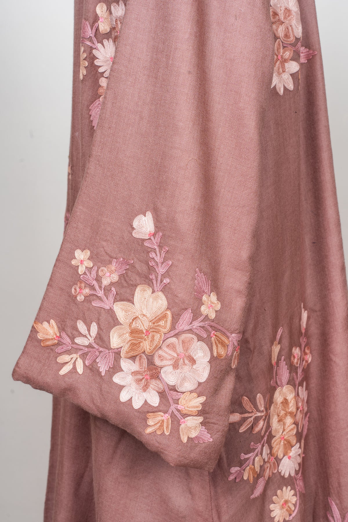 Sleeve detail of a dusty rose abaya with pale pink, peach and ivory Aari flowers near the cuff