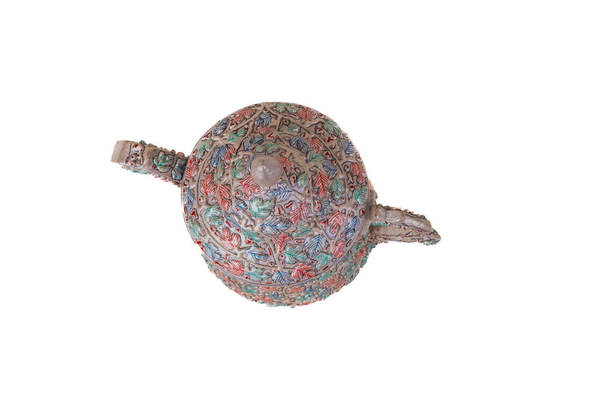 Overhead view of the floral-painted teapot, showing the round domed lid between its spout and handle.