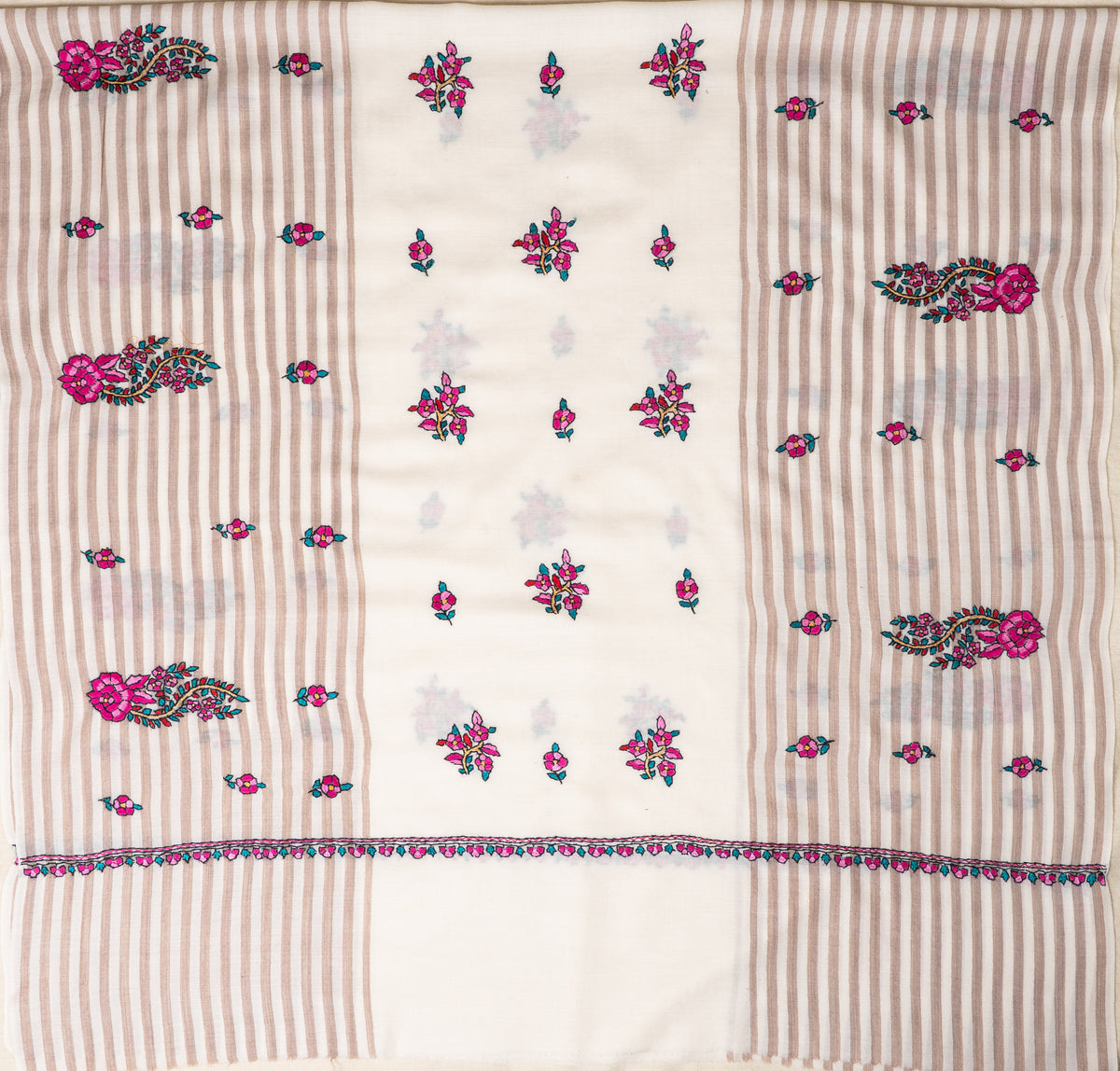 Ivory shawl spread flat, with beige striped side panels, fuchsia floral paisleys and scattered small flowers