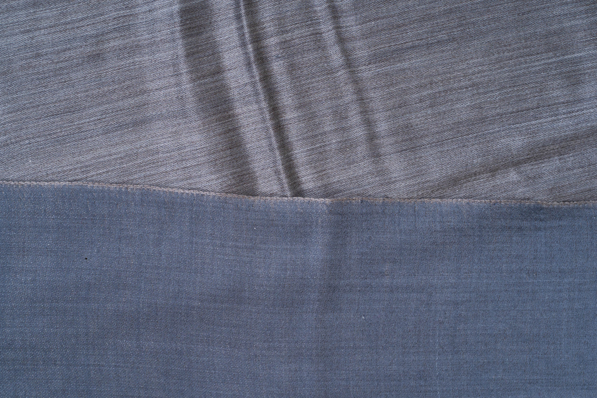 Close-up of overlapping steel blue and slate grey sides of a reversible Merino wool stole