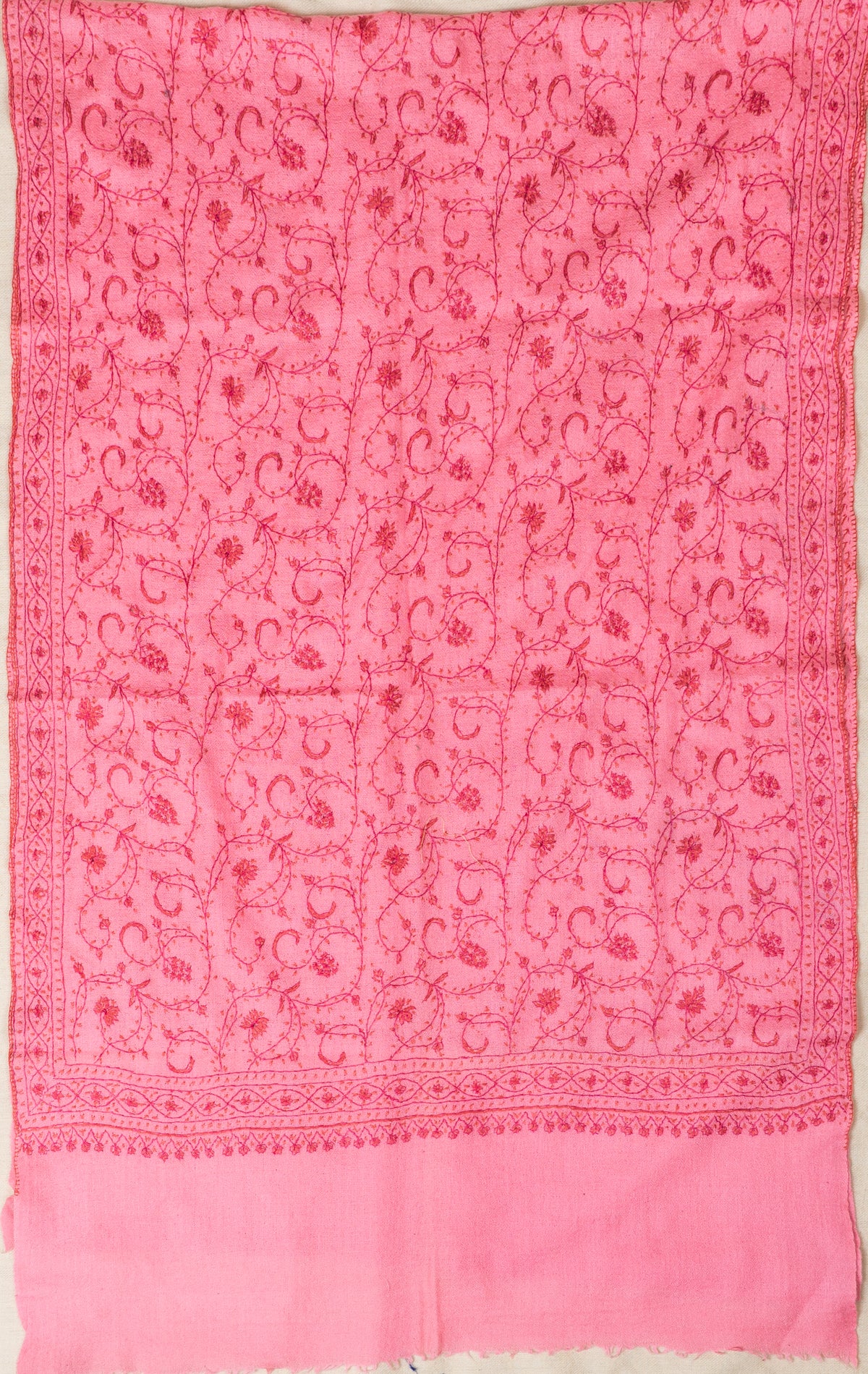 Pink stole spread lengthwise, showing its dense Sozni vine pattern, narrow side borders and plain fringed end