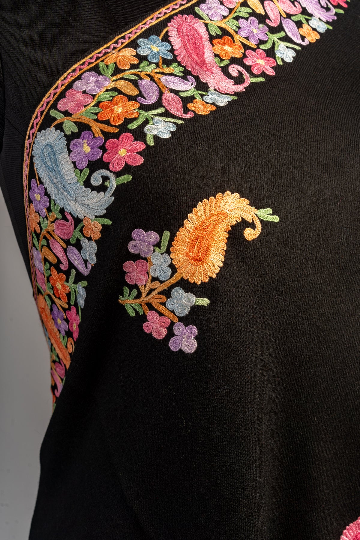 Close-up of the black stole showing an orange paisley and small flowers beside the multicoloured embroidered border.