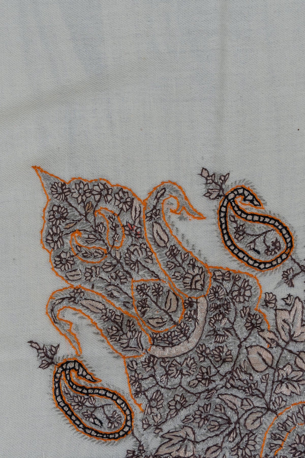 Detail of charcoal Sozni flowers and curling paisleys outlined in ochre on an ivory rumal
