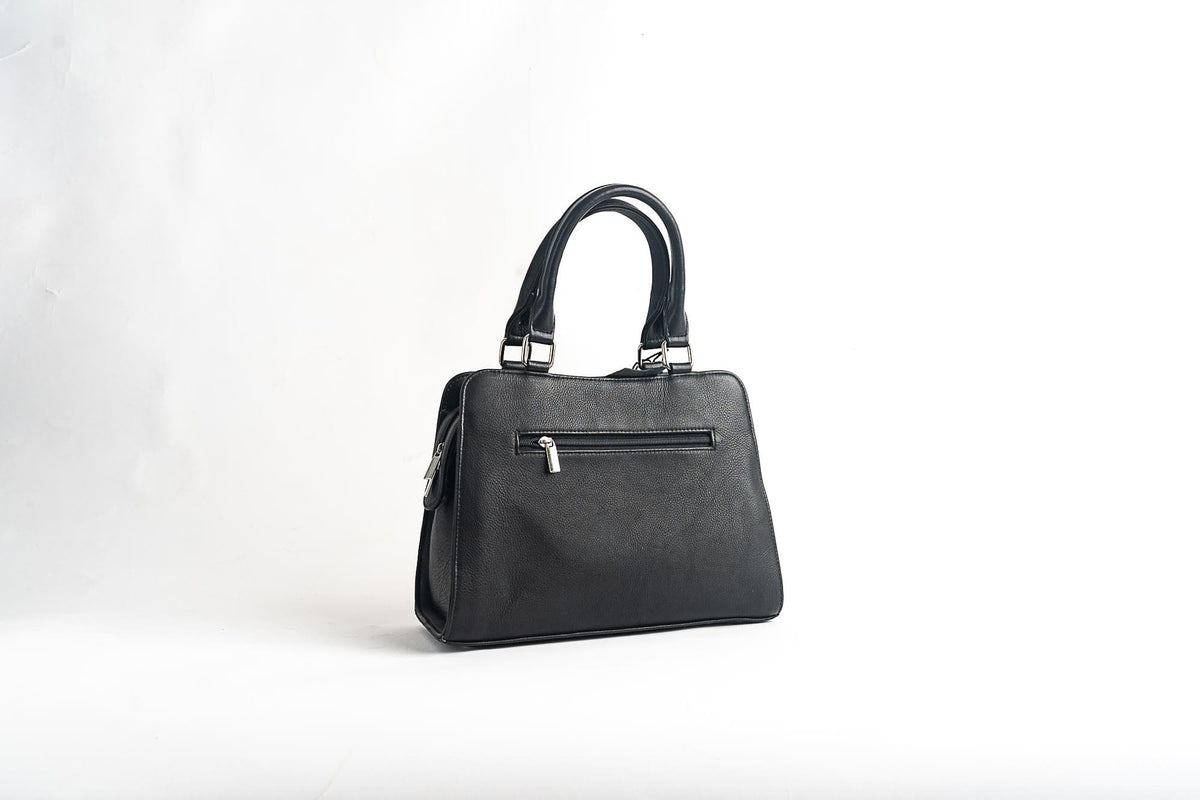 Back view of a black two-handle handbag with a plain rear panel and a horizontal zip pocket