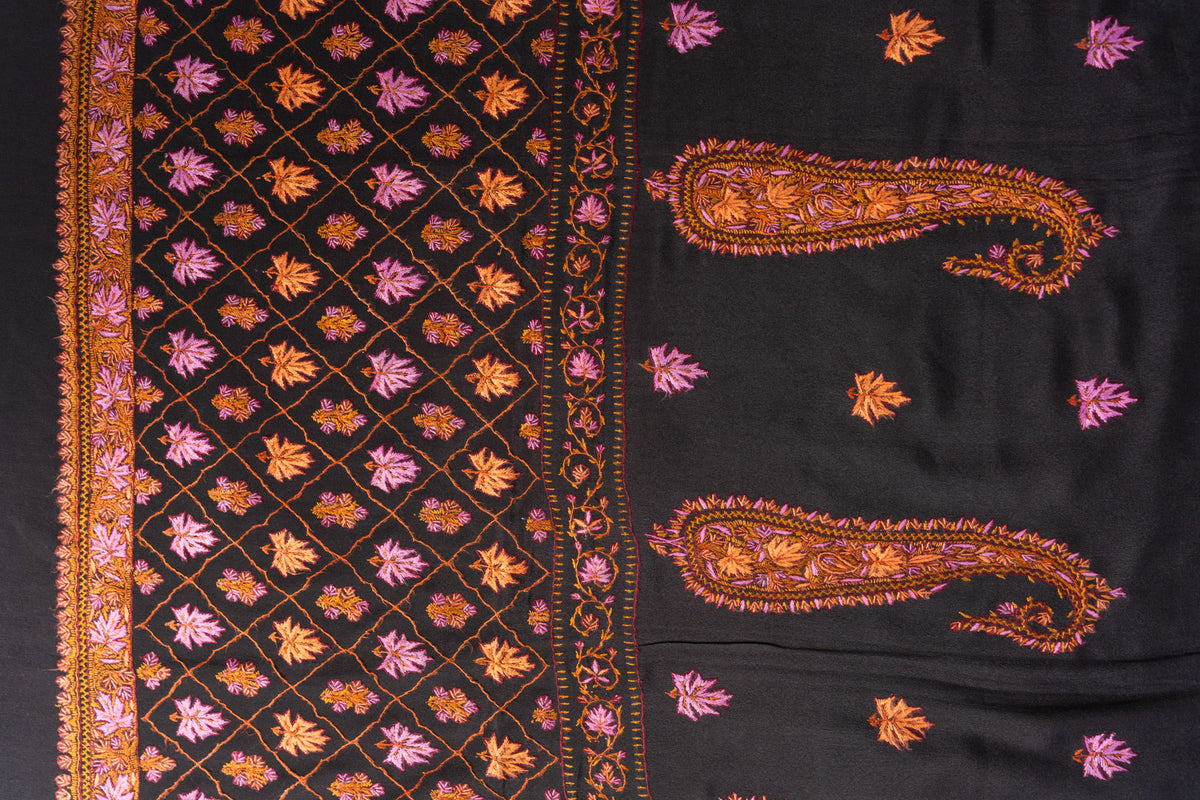 Flat detail of a black crepe saree with two orange Sozni paisleys beside a pink and orange diamond lattice panel