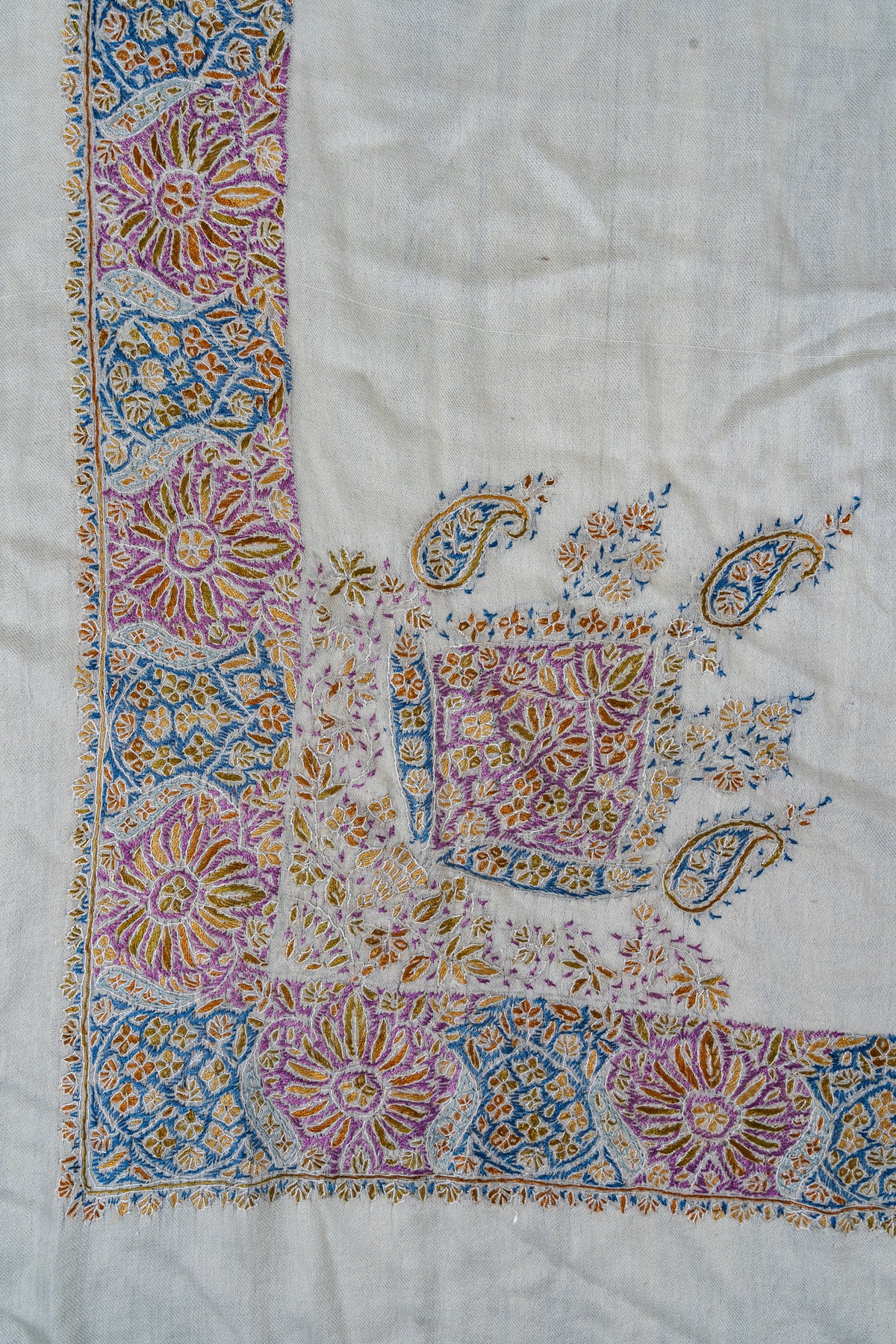 Ivory rumal corner with a purple floral medallion, small blue paisleys and a wide purple, blue and gold Sozni border