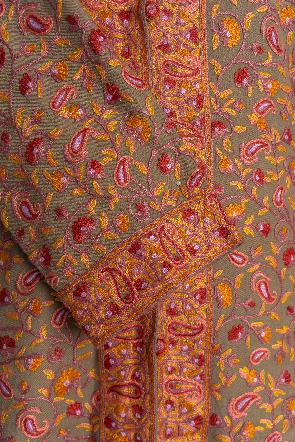 Brown jacket detail with pink and orange Aari paisley borders on the front opening and folded sleeve cuff