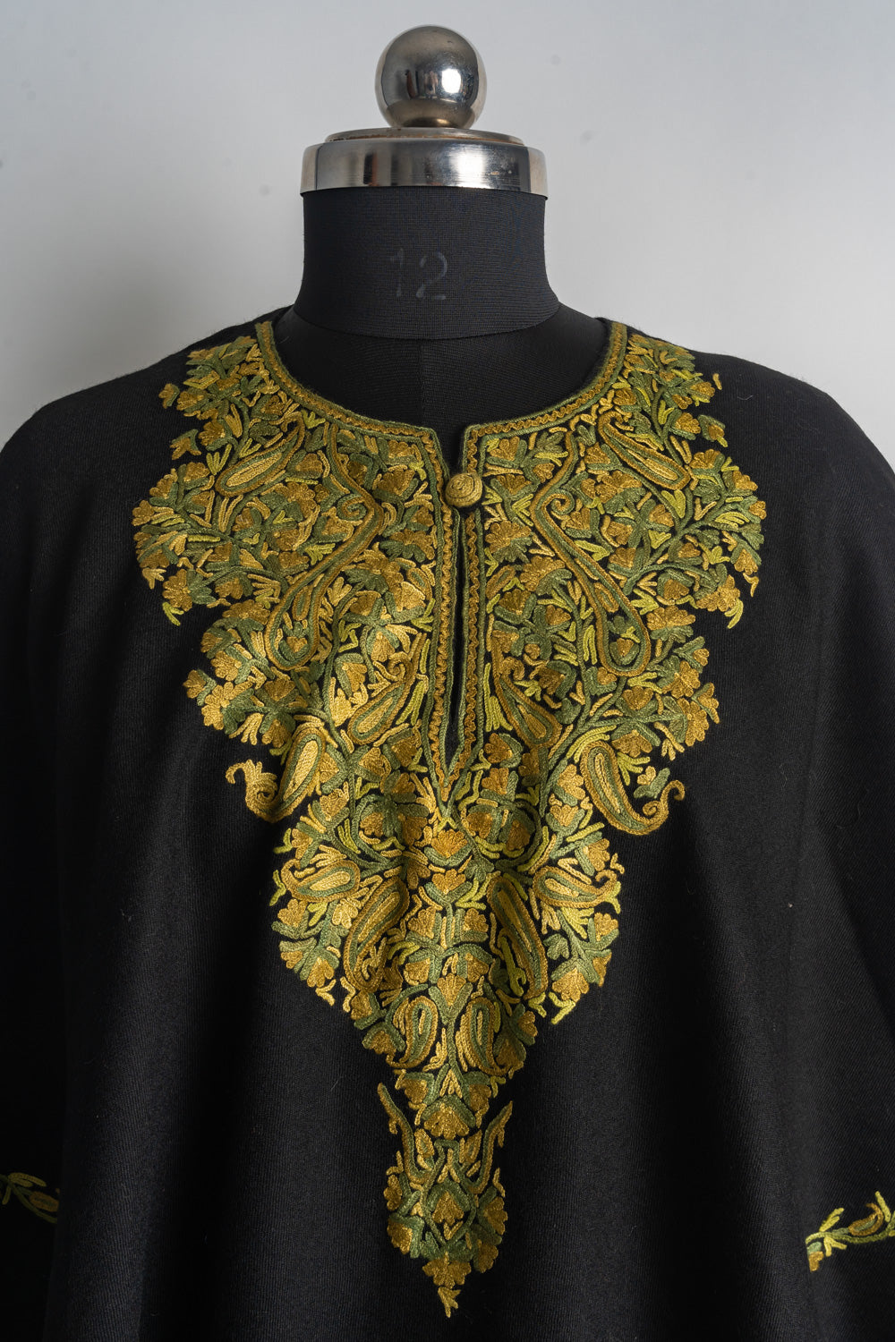 Black poncho with a long pointed Aari neckline panel of golden yellow paisleys, flowers and olive green leaves