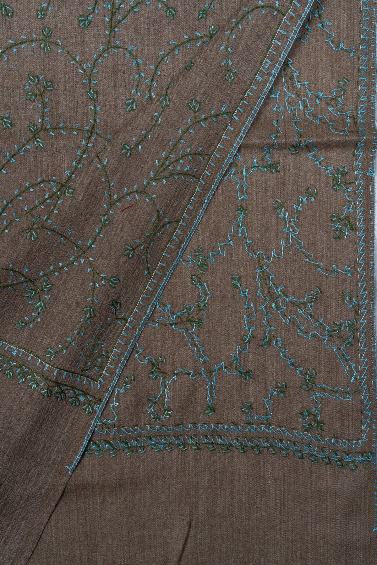 Folded taupe stole corner showing both sides of teal Sozni vine embroidery and a narrow border