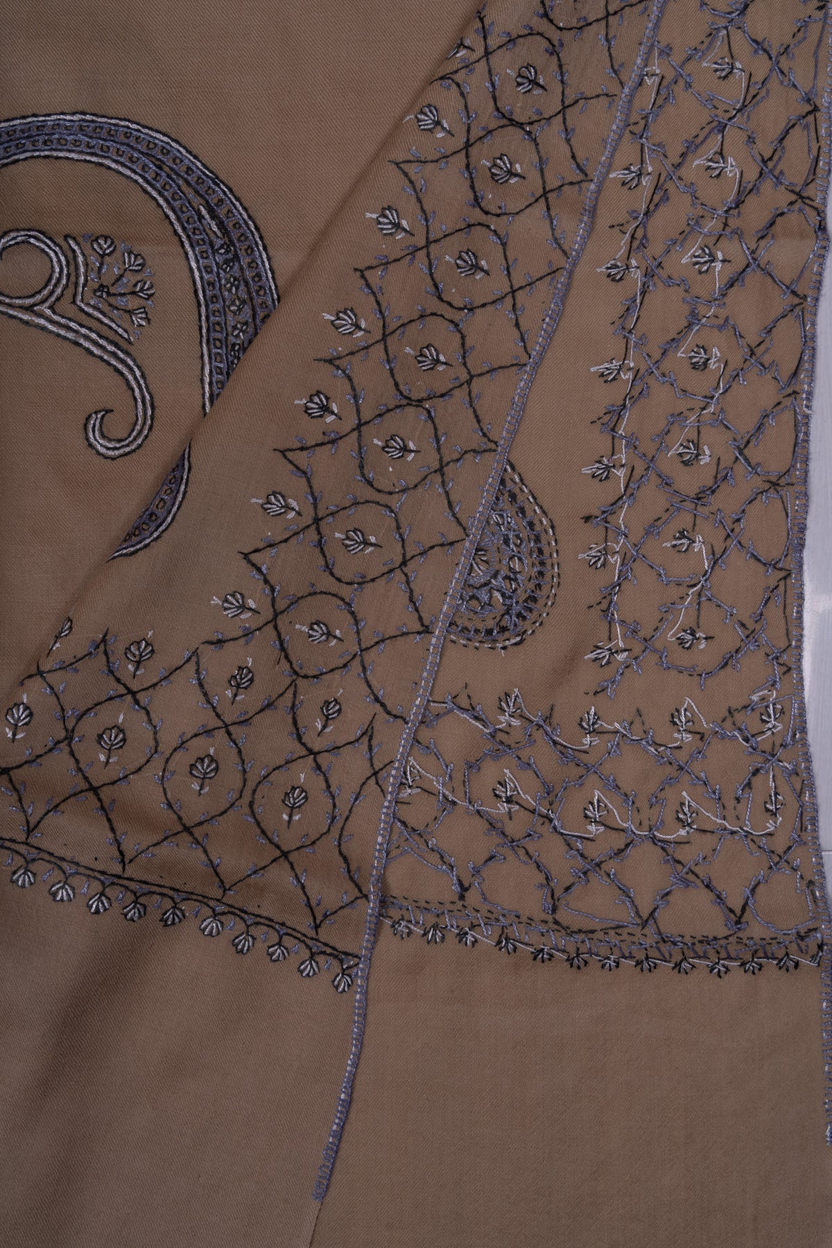 Desert-beige shawl folded back to show overlapping blue-grey Sozni lattice borders and paisley motifs