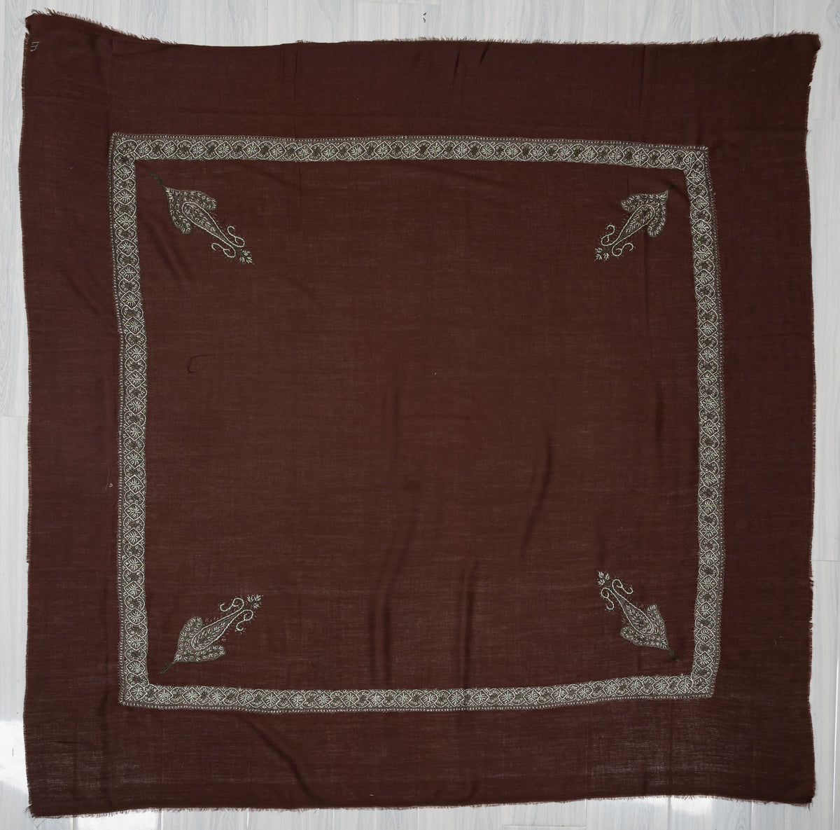 Square chestnut-brown rumal laid flat with four silver-grey Sozni corner paisleys, a narrow border and a plain centre