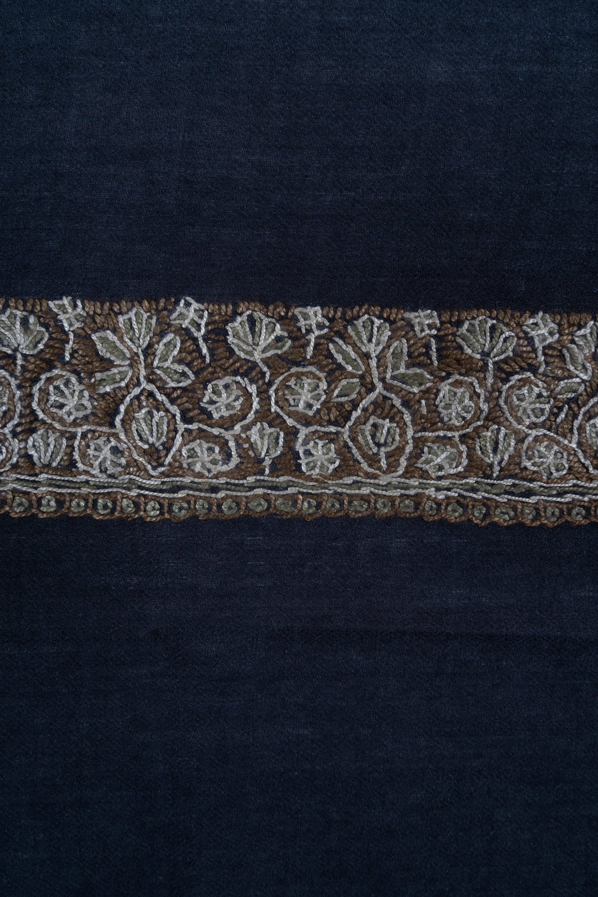 Detail of the gold and ivory Sozni floral border running across navy rumal fabric