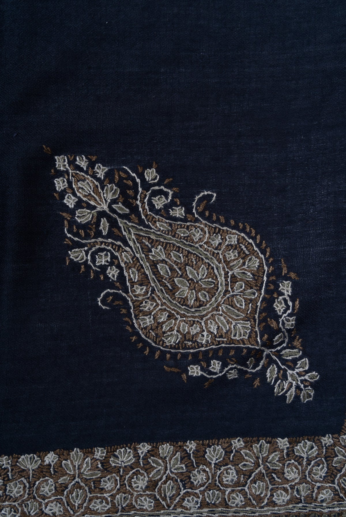 Detail of a gold Sozni paisley filled with ivory flowers on a navy rumal