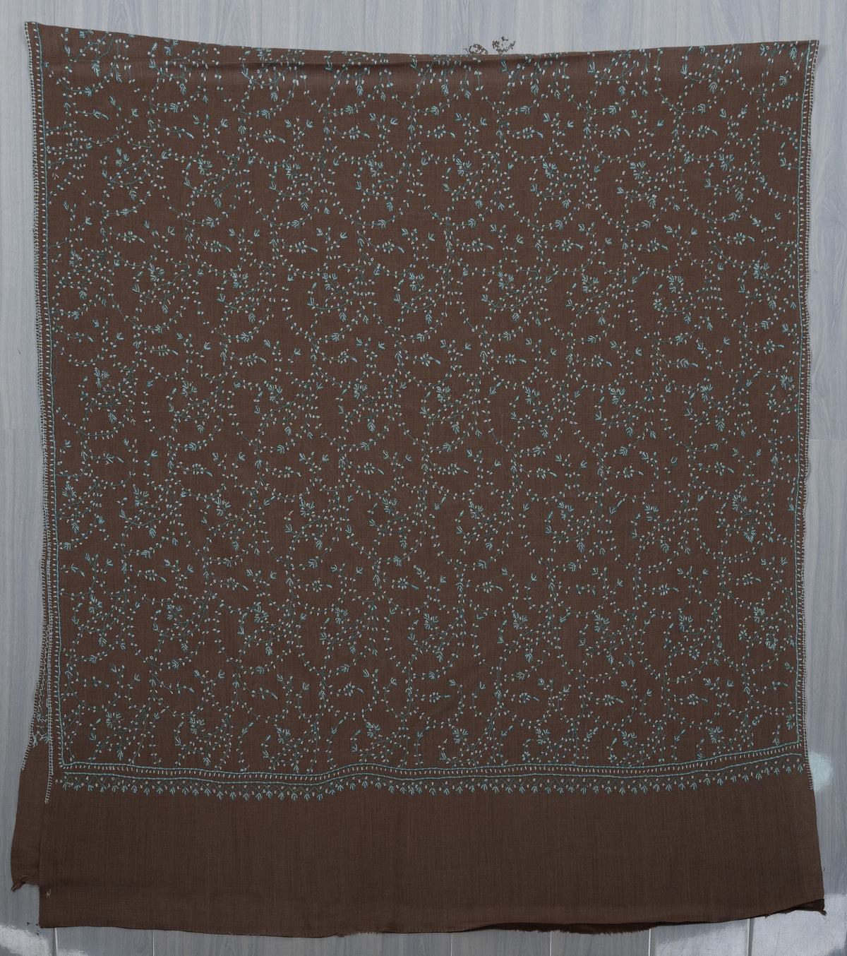 Cocoa-brown shawl laid flat with pale aqua Sozni vines, narrow embroidered borders and a plain end band