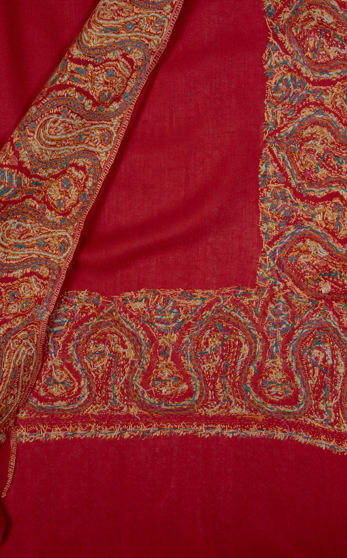 Overlapping scarlet shawl corners showing broad golden Sozni paisley borders with blue-green accents