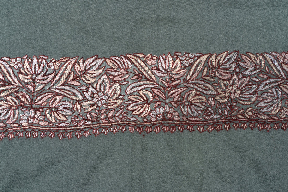 Close view of the rumal’s dense cream and brown floral border with small hanging leaf edging