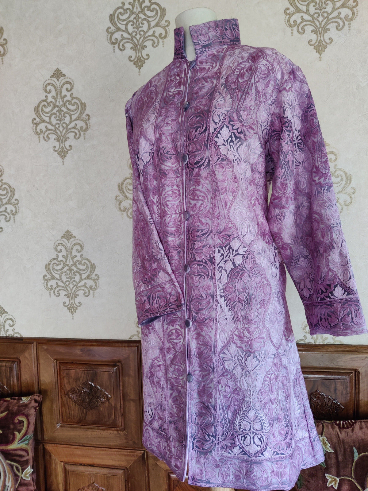 Angled full view of a purple tie-dye jacket with tonal paisley embroidery and a high stand collar.