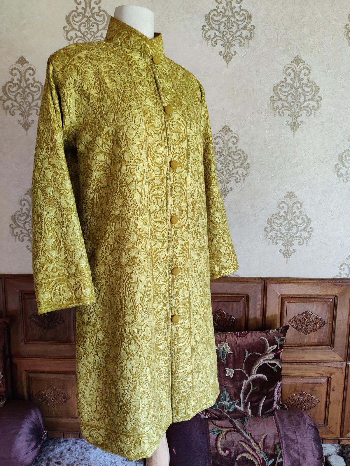 Three-quarter front of the mustard-yellow Aari jacket with a standing collar, covered buttons and all-over tonal embroidery.