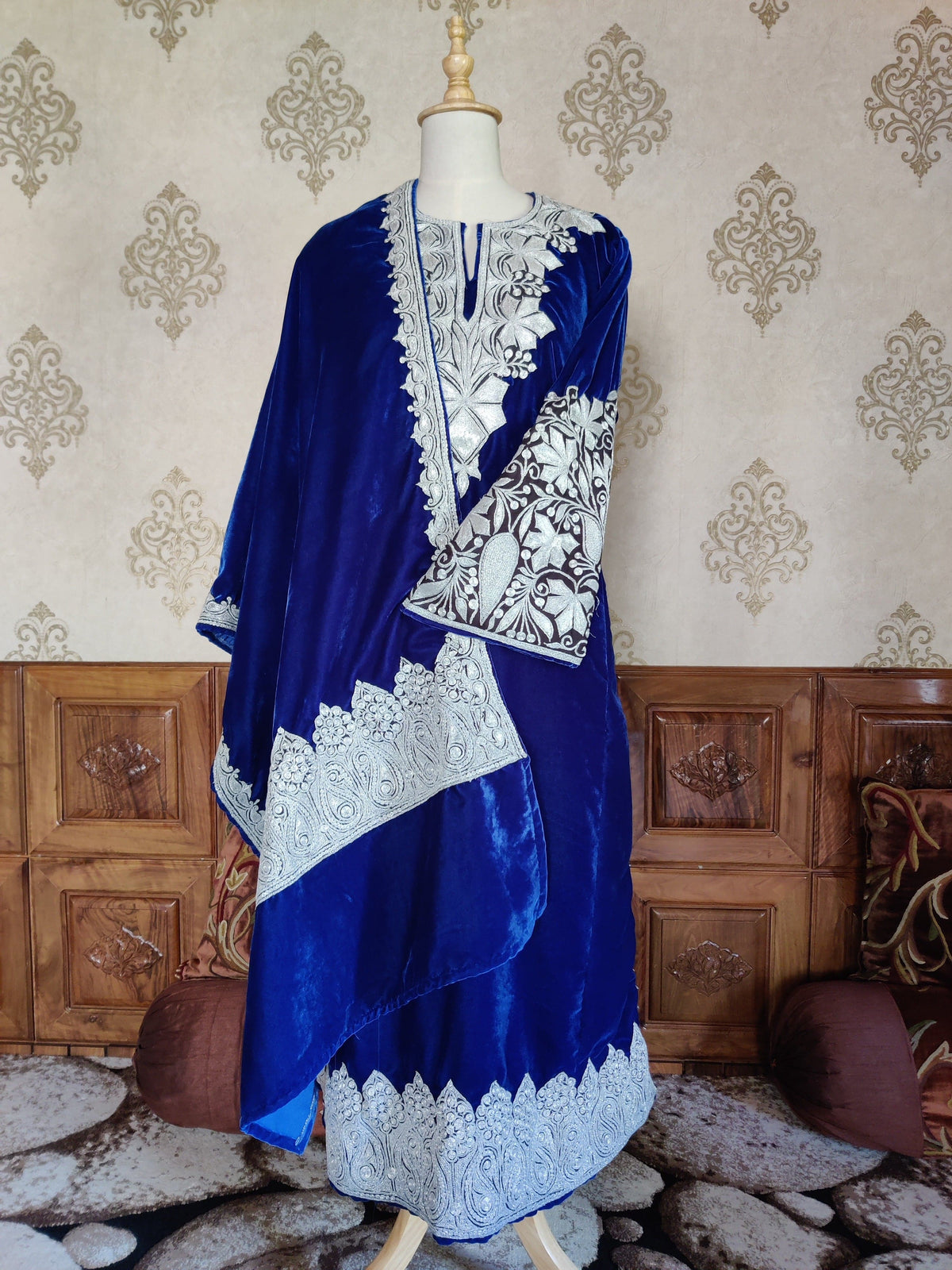 Front view of the blue velvet pheran with its matching stole draped diagonally, showing silver-toned neckline, cuff and hem embroidery.