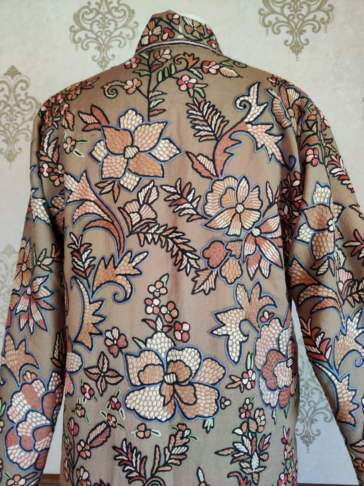 Upper back of the beige wool Hand Aari jacket, showing the embroidered collar and large pastel flowers