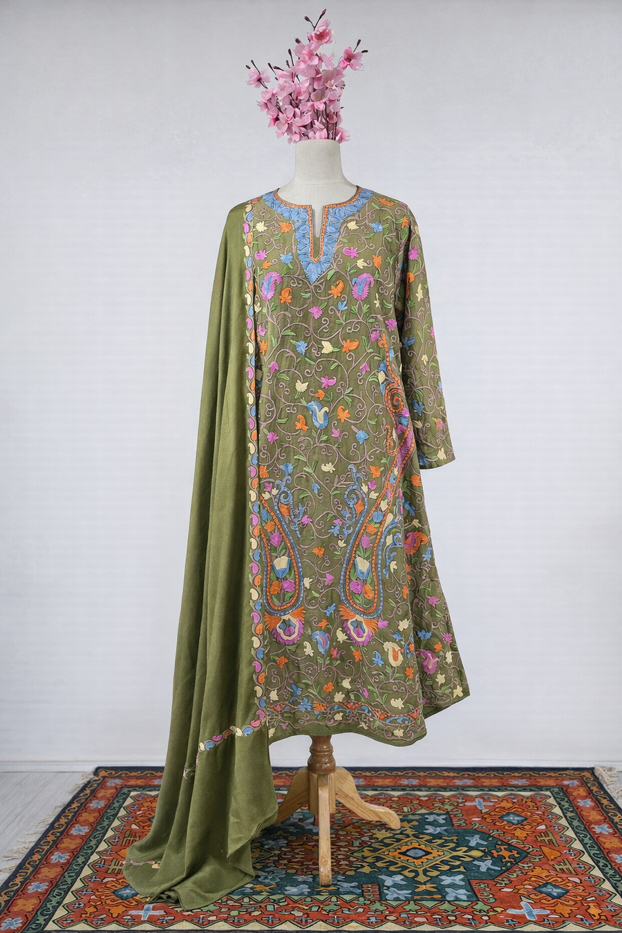 Green embroidered dress on a mannequin with a white background