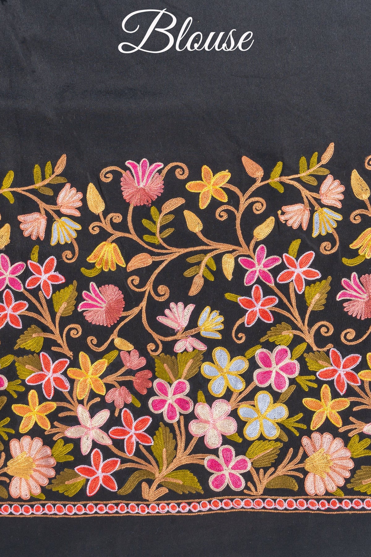 Black blouse fabric with a broad multicoloured Aari floral border and the word “Blouse” above the embroidery.