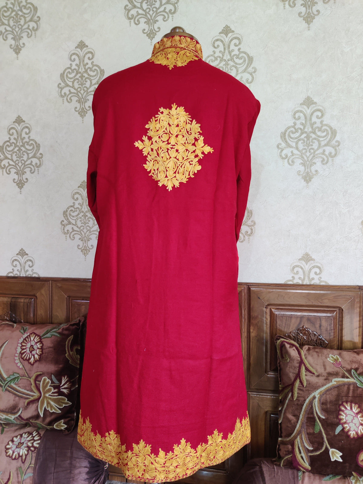 Back of the maroon jacket with a central golden-yellow Aari floral medallion, embroidered collar and floral hem border.