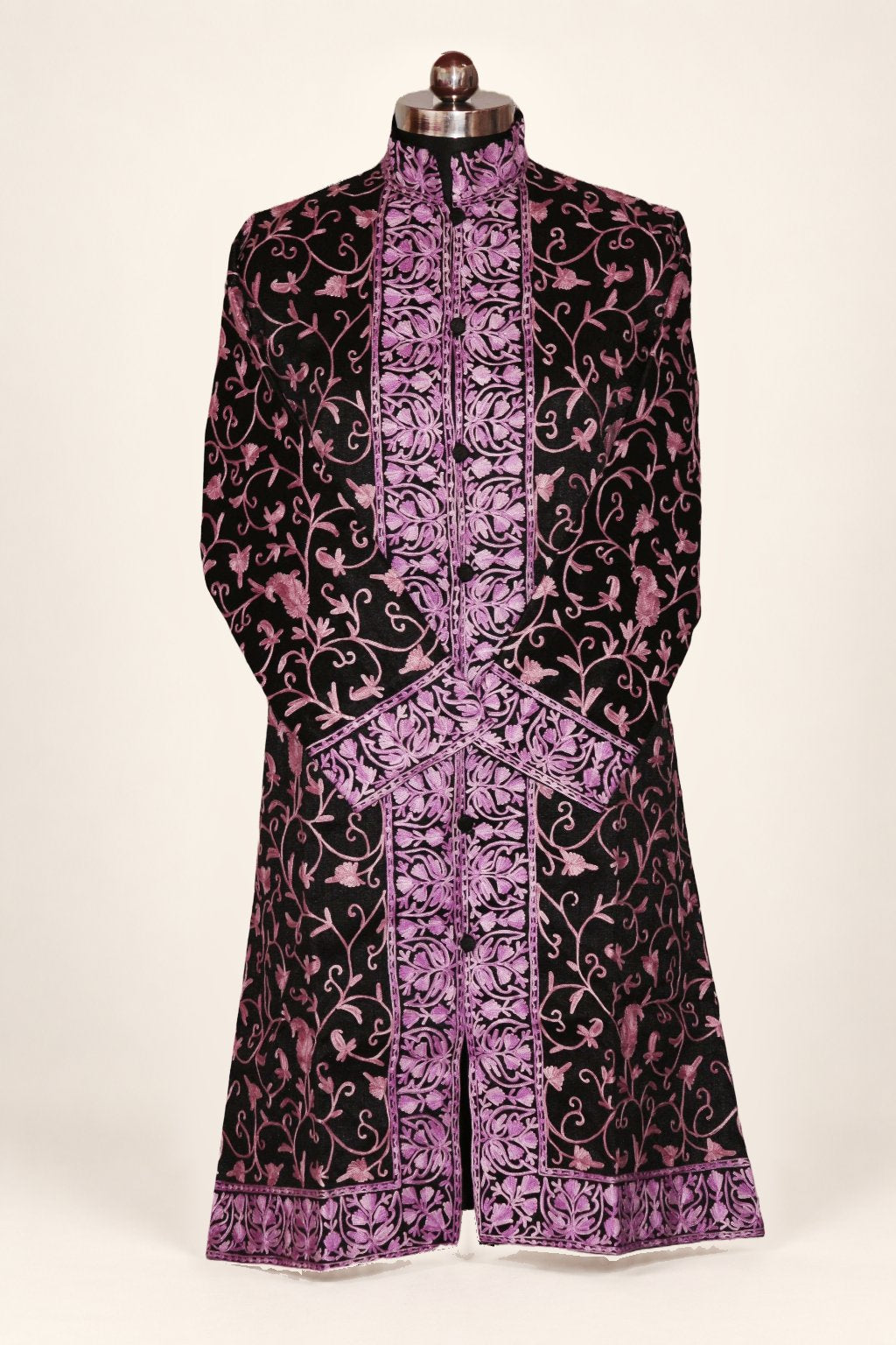 Front view of a black long coat with purple Aari vines, an embroidered stand collar and crossed sleeves