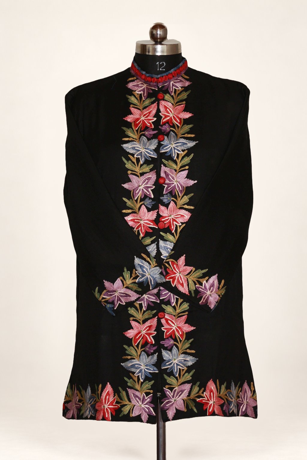 Black Kashmiri jacket on a mannequin, with multicoloured Aari chinar-leaf motifs along the front, cuffs and hem