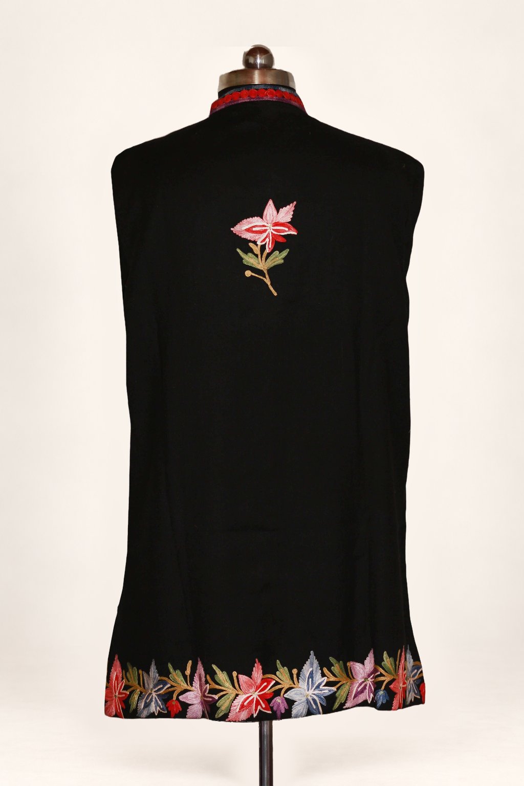 Back view of the black jacket, with a small pink Aari leaf sprig between the shoulders and multicoloured chinar leaves along the hem
