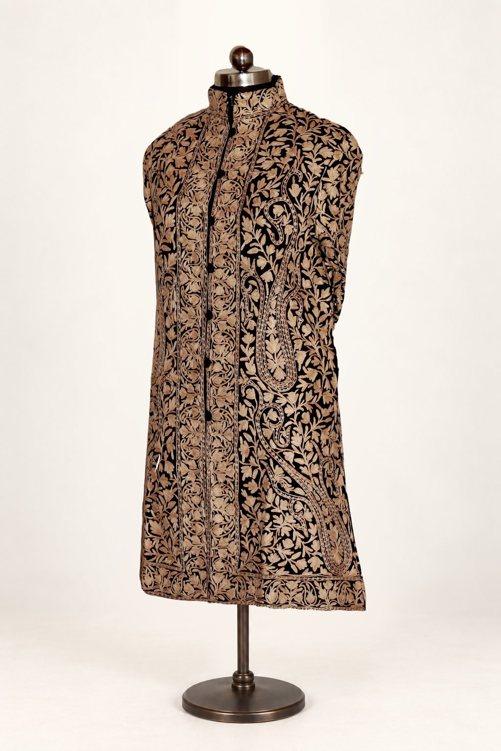Front view of a black long jacket with all-over golden floral and paisley Aari embroidery and a stand collar