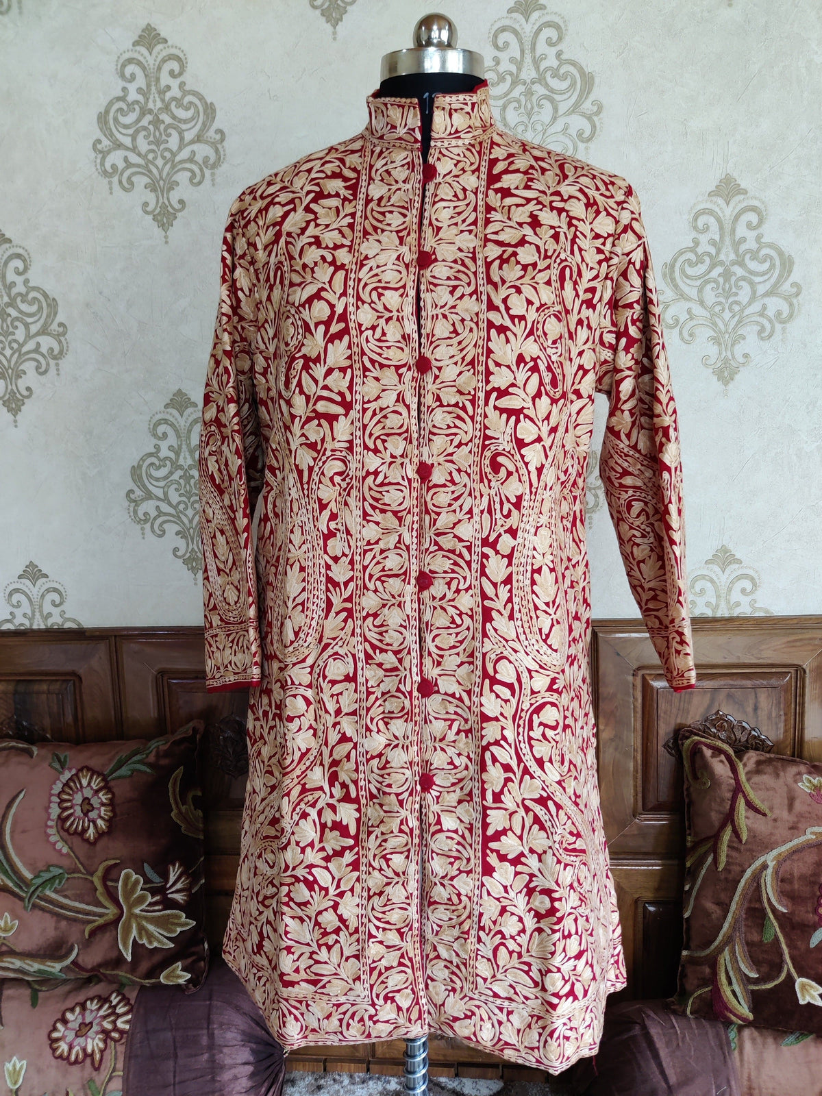 Full front view of a maroon woollen jacket with cream paisley embroidery and a stand collar.