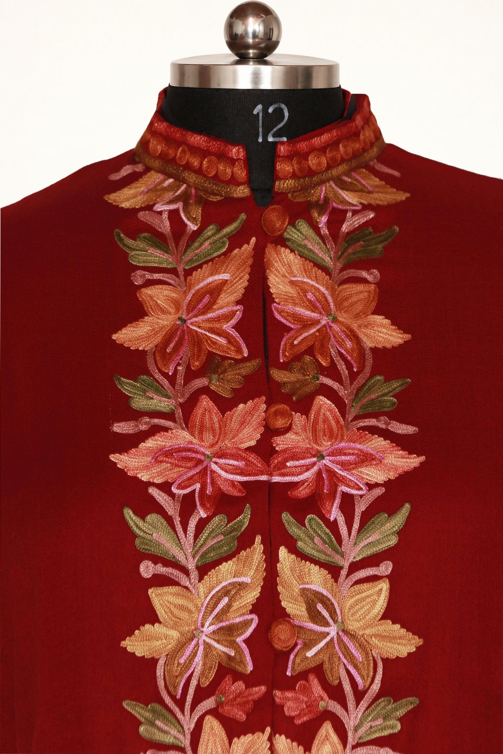 Front close-up of maroon jacket showing a standing collar, covered buttons and peach, pink and green Aari floral embroidery