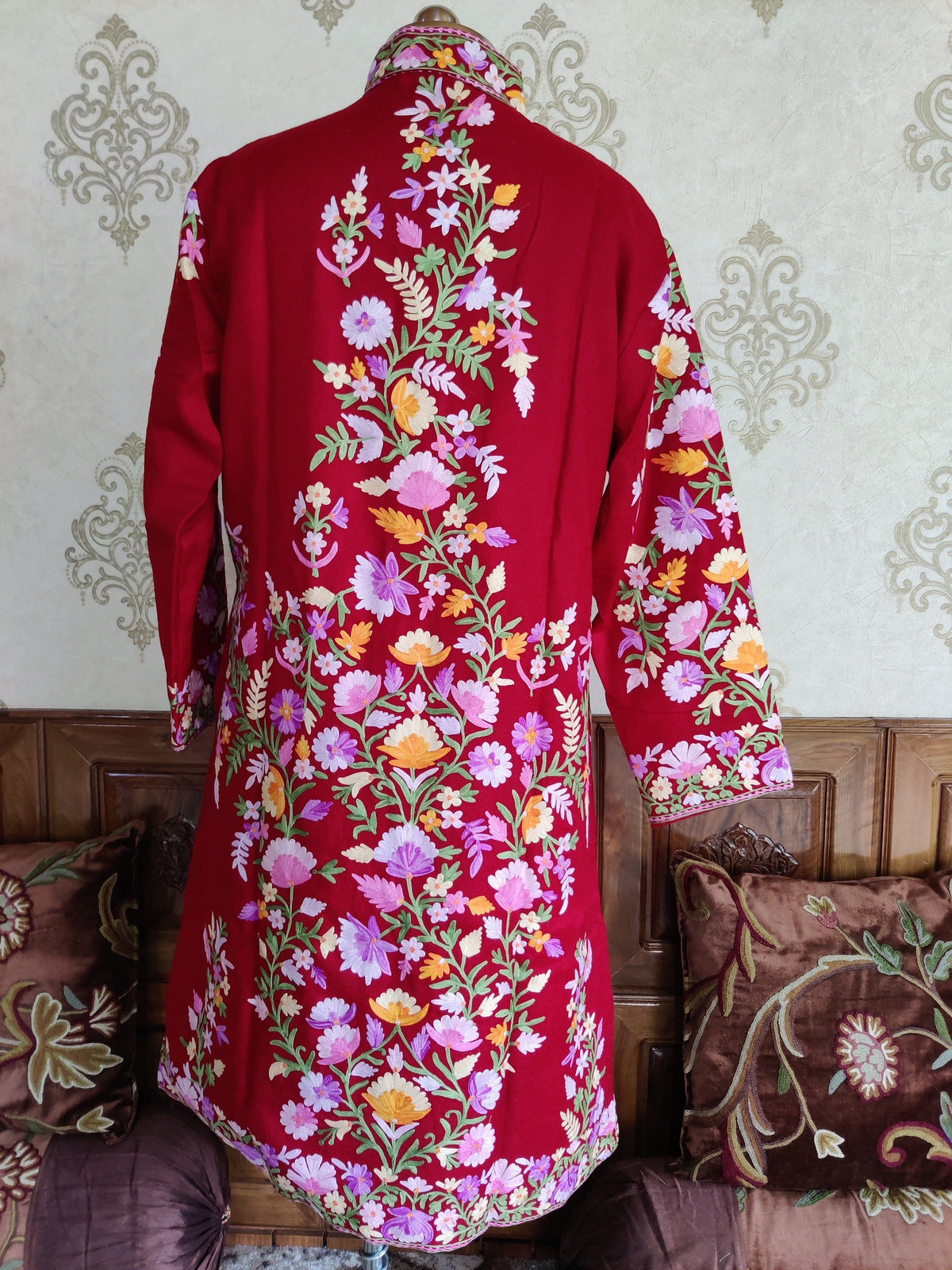 Back of a maroon jacket with a central trail of pink, lavender and yellow flowers spreading across the lower back.