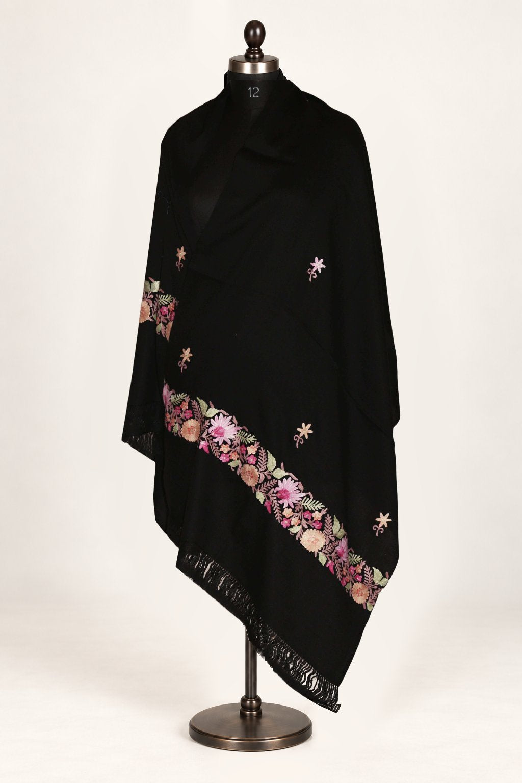 Black Merino wool stole draped around a mannequin, with pink Aari floral borders, scattered flowers and fringed ends