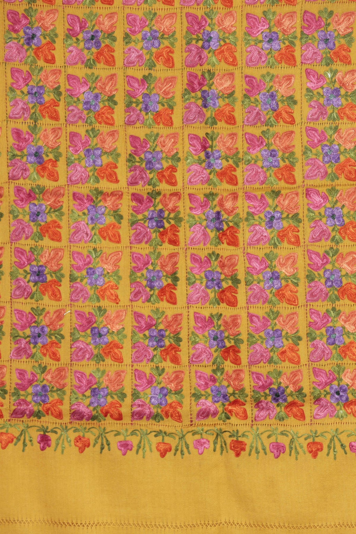 Yellow Merino wool scarf detail with a grid of pink, orange and blue Aari floral squares above a plain yellow end