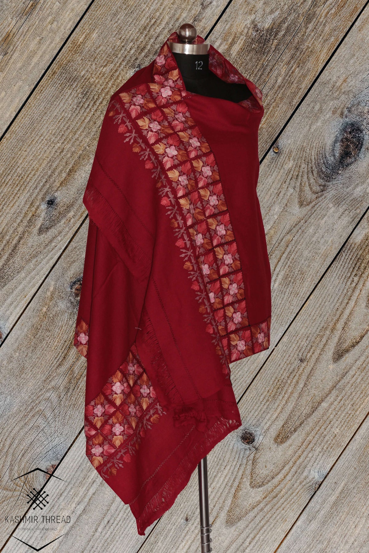 Maroon Merino wool stole draped on a mannequin, with floral Aari cutwork borders around a plain centre