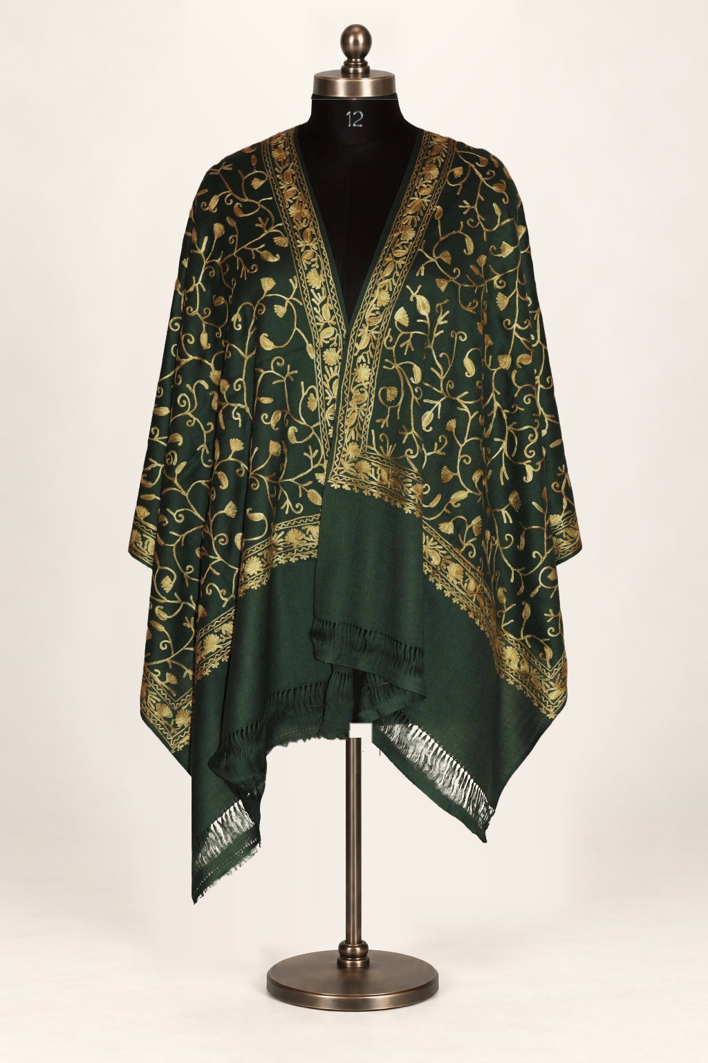 Green Merino wool stole draped across a mannequin’s shoulders, with gold-toned Aari vines, embroidered borders and fringe