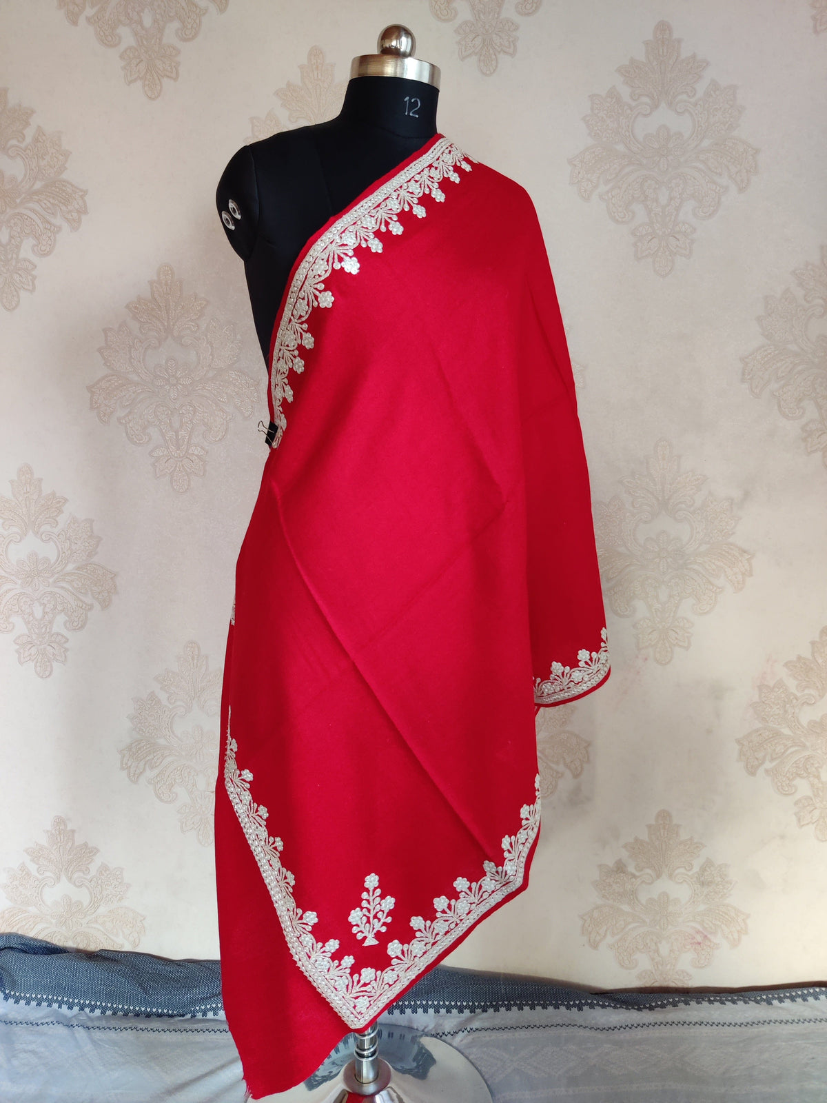 Full-length red Merino wool scarf draped on a mannequin, with silver-toned Tilla floral borders and small corner sprigs