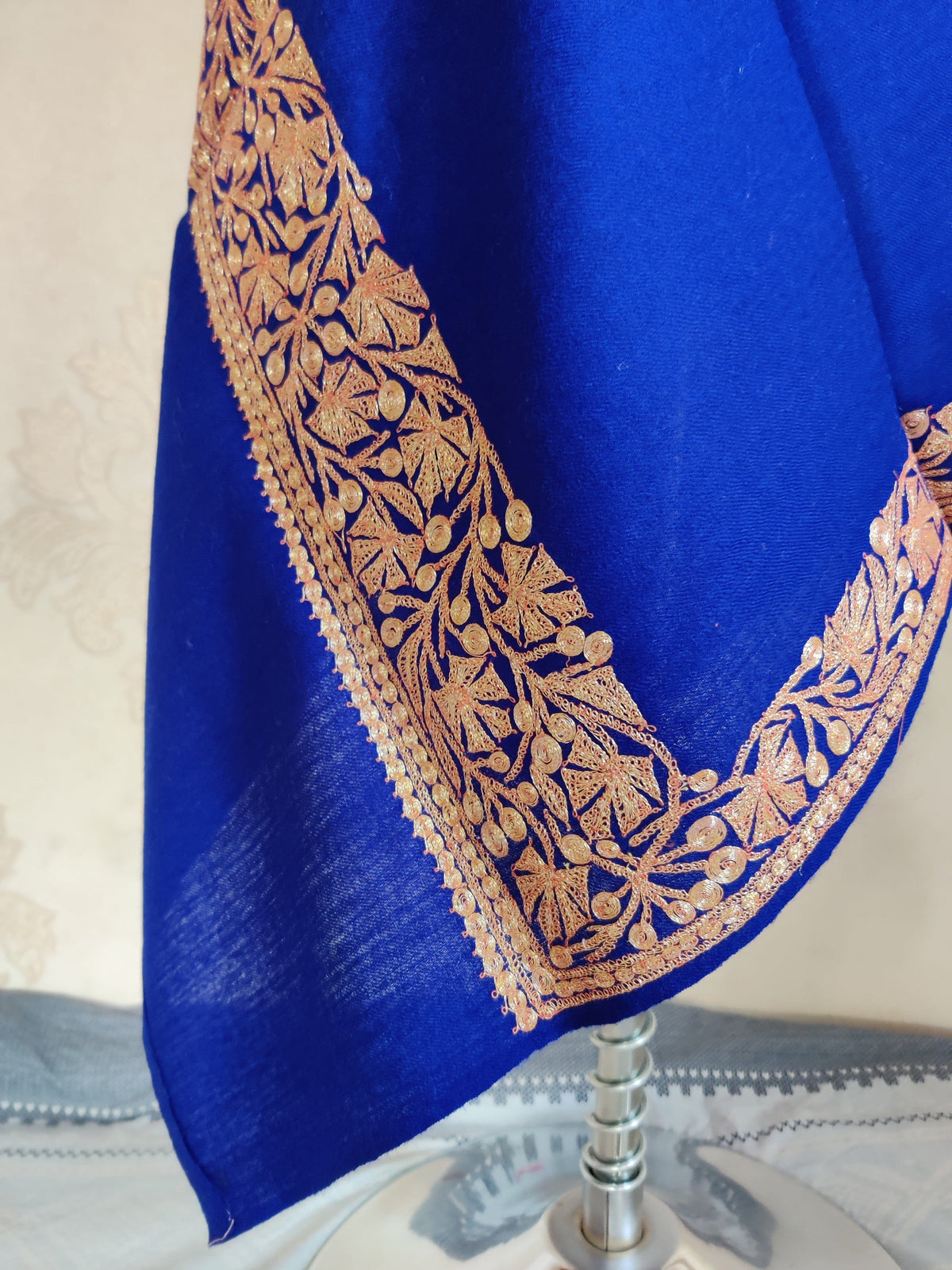 Draped corner of the royal-blue stole with a gold-toned maple-leaf and curling-vine border.